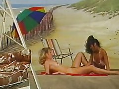 Dues lesbianes a jugar a la platja de fons